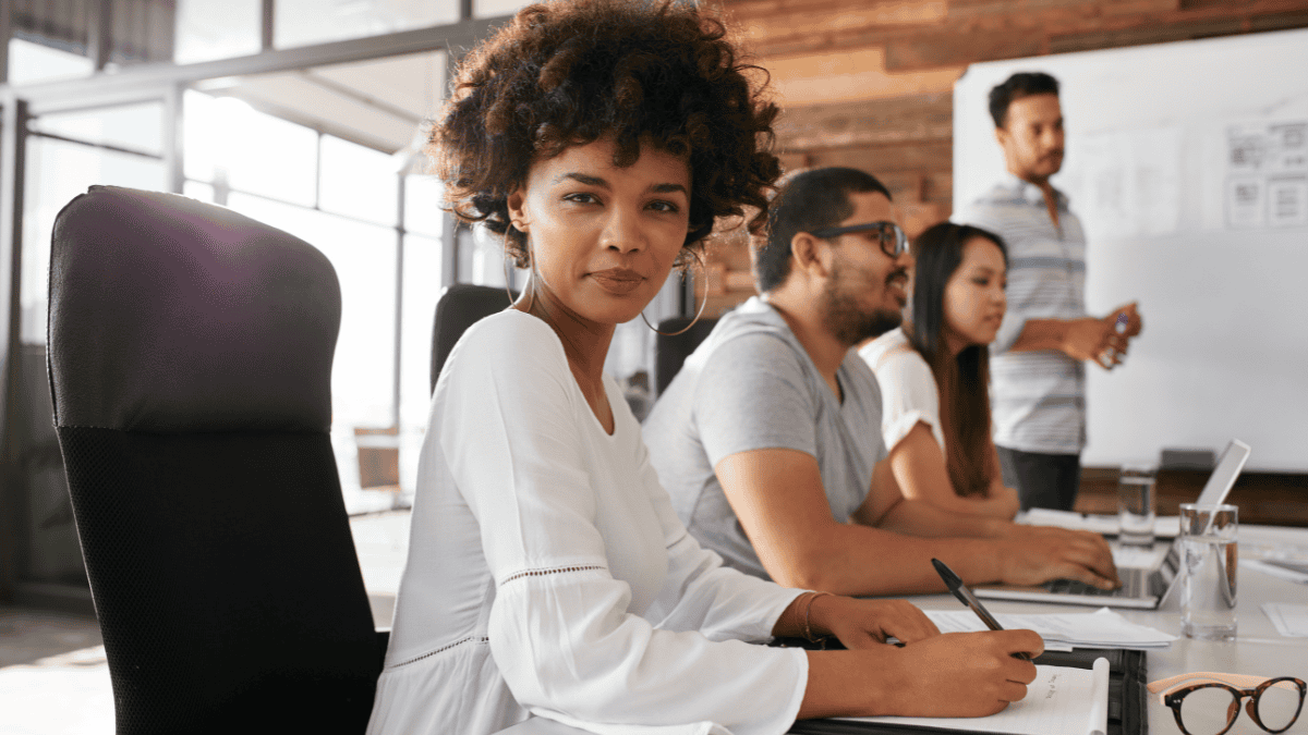 Confident female leader participating in a team meeting, representing courage and emotional intelligence in leadership.
